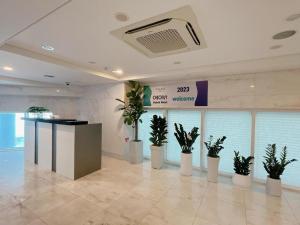 a lobby with potted plants in a building at THE AVA HOTEL JEJU in Jeju