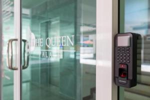 Ban Bang TalatにあるThe Queen Palaceの携帯電話がガラスのドアに付いています
