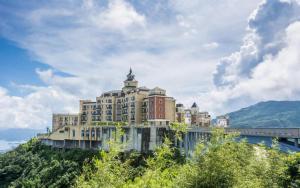 a large building on top of a hill with a bridge at eLong Hotel (HUA Shenzhen Bay Branch) in Shenzhen