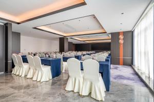 a conference room with blue tables and white chairs at The Puyan Hotel Hangzhou Jiubao in Hangzhou
