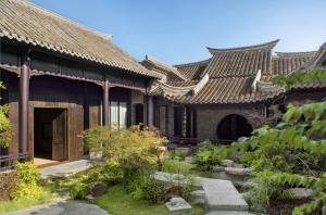 a building with a garden in front of it at Blossom House Xuzhou Huilongwo Banyunting in Xuzhou