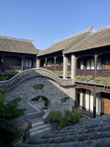 a building with a stone staircase in front of it at Blossom House Xuzhou Huilongwo Banyunting in Xuzhou