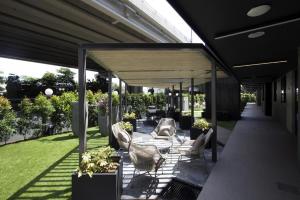a covered patio with chairs and tables and plants at Coliwoo Keppel Serviced Apartments in Singapore