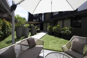 an outdoor patio with chairs and an umbrella at Coliwoo Keppel Serviced Apartments in Singapore