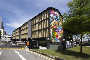 a building with a colorful mural on the side of it at Coliwoo Keppel Serviced Apartments in Singapore