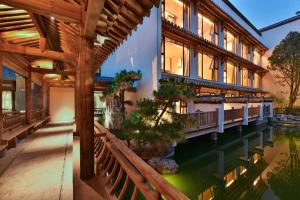 済南市にあるBlossom House Jinan Shunluの池のある建物の外観
