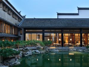 済南市にあるBlossom House Jinan Shunluの池を前に建つ建物