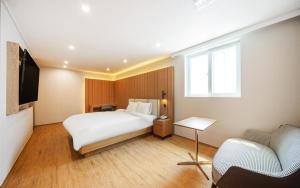 una camera d'albergo con letto e TV di H Avenue Gyeongju a Gyeongju