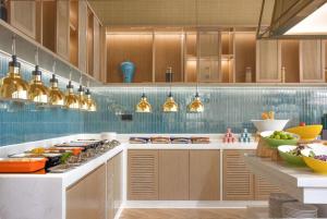 a kitchen with a counter with a stove top oven at Home2 Suites by Hilton Xishuangbanna in Jinghong