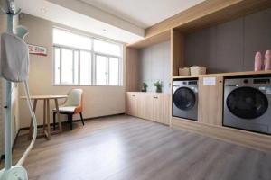 a laundry room with a washer and dryer in it at Echarm Hotel Zhanjiang Zhanchuan Avenue Wanda Plaza in Zhanjiang +48 photos