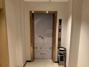 a elevator in a building with a door in a room at City Comfort Inn Changsha Sifangping University of National Defense Science and Technology in Changsha