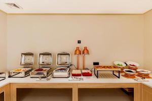 ein Raum mit einem Tisch voller Behälter mit Lebensmitteln in der Unterkunft City Comfort Inn Fengcheng Recycle Park Geliyang  + 41 Fotos