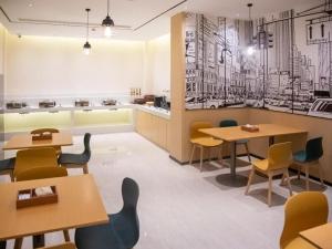 a restaurant with tables and chairs in a room at City Comfort Inn Qianjiang Government in Qianjiang