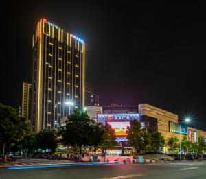 una città di notte con un grande edificio con luci di Borrman Hotel Zhangzhou Baolong Plaza a Zhangzhou