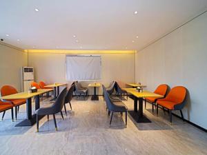 a dining room with tables and chairs and a whiteboard at City Comfort Inn Zhongshan Hot Spring Resort Sanxiang Shunchang Plaza in Zhongshan