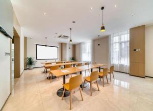 une salle de classe avec des tables et des chaises et un écran de projection dans l'établissement City Comfort Inn Hotel Taizhou Jiangyan 2nd Affiliated Middle School Railway Station, à Guanzhuang
