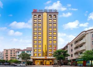 a tall yellow building with many windows on a street at Borrman Hotel Zhanjiang Jinshawan Chikan Republic of China Style Street in Zhanjiang