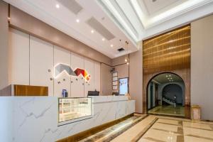 a lobby of a building with a counter and a hallway at Borrman Hotel Zhanjiang Jinshawan Chikan Republic of China Style Street in Zhanjiang