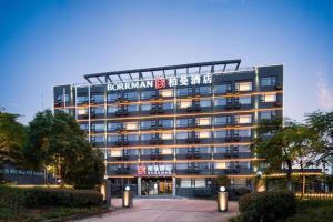 a building with a sign on the side of it at Borrman Hotel Wuhan Optics Valley Fozuling Gaoxin 4th Road in Liufangling