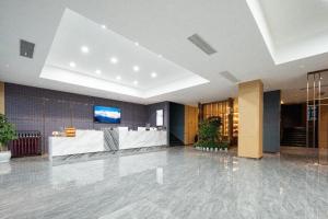 a lobby with a reception desk in a building at Borrman Hotel Wuhan Optics Valley Fozuling Gaoxin 4th Road in Liufangling