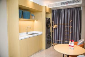 a kitchen with a table and a sink and a laundry room at City Comfort Inn Badong Passenger Transport Center in Badong