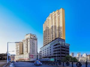貴陽市にあるEcharm Hotel Guiyang Zhongshan West Road Metro Stationの高層ビルと路上車のある街