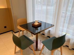 stół z dwoma krzesłami i pudełko na nim w obiekcie City Comfort Inn Ezhou Wuyue Plaza w mieście Quelingzui