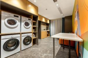 a laundry room with two washer and dryer at City Comfort Inn Yichang Zhongnan Road Changjiang Plaza in Baiyang
