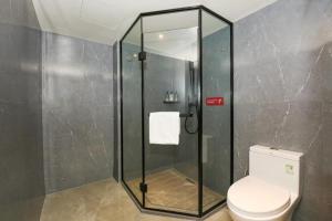 廣州的住宿－Echarm Hotel Guangzhou Shiergong Metro Station，浴室设有玻璃淋浴间和卫生间
