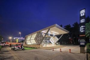 南寧的住宿－Borrman Hotel Nanning Anji Passenger Station Xijin Metro Station，夜间与摩托车上的人一起建造的建筑物