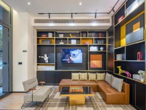 un salon avec un canapé et une télévision dans l'établissement City Comfort Premier Hotel Qinzhou Lingshan Traditional Chinese Medicine Hospital Gymnasium, à Lingshan