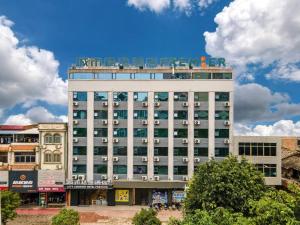 un grand bâtiment blanc avec des fenêtres au sommet dans l'établissement City Comfort Premier Hotel Qinzhou Lingshan Traditional Chinese Medicine Hospital Gymnasium, à Lingshan