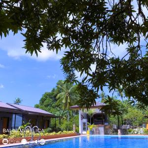 a swimming pool in front of a house and a building at Balai Angelica - Nature Farm & Resort in Pagsanjan