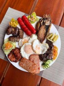 a plate of food with eggs and vegetables on a table at Balai Angelica - Nature Farm & Resort in Pagsanjan