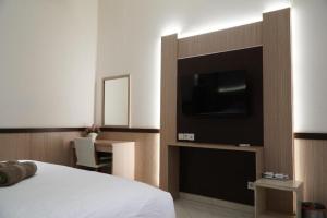 1 dormitorio con 1 cama, TV y escritorio en Paris Day Hotel, en Pamanukan-hilir