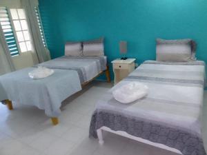 a room with two beds and a table in it at The Resort at West End in Negril