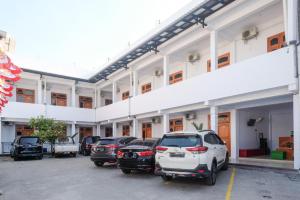 a group of cars parked outside of a building at Urbanview Syariah Wisma Nabil Solo in Lawean