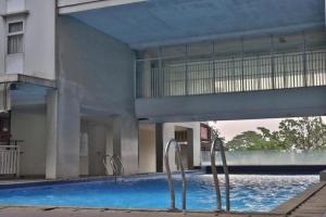 茂物的住宿－Buka Room Apartemen Bogor Valley，一座大型建筑,设有一座带两个金属棒的游泳池