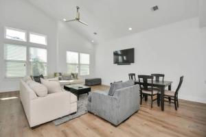 a living room with white furniture and a dining room at 6 Mins to Dwtn /12 Mins to Rodeo in Houston