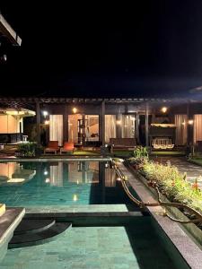 una piscina en una casa por la noche en Shankara Munduk Bali, en Munduk