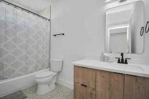 a bathroom with a toilet and a sink and a mirror at 6 Mins to Dwtn /12 Mins to Rodeo in Houston