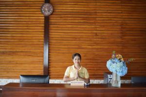una mujer sentada en un escritorio con un portátil en Shankara Munduk Bali, en Munduk