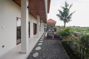 un corridoio di una casa con piante e una palma di Kerti Suite a Tanah Lot