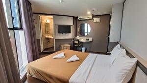 a bedroom with a bed with two napkins on it at Urban Inn, Jitra in Jitra