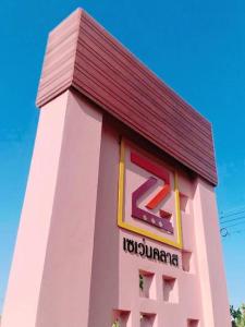 a large pink building with a sign on it at 7 Class Pool Villa in Chachoengsao