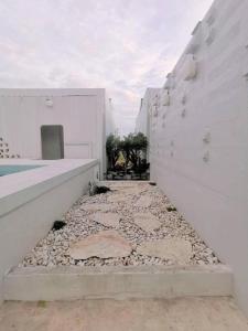 a walkway with rocks on the side of a building at 7 Class Pool Villa in Chachoengsao