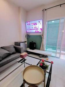 sala de estar con sofá y TV en 7 Class Pool Villa, en Chachoengsao