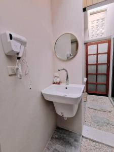 a white bathroom with a sink and a mirror at 7 Class Pool Villa in Chachoengsao
