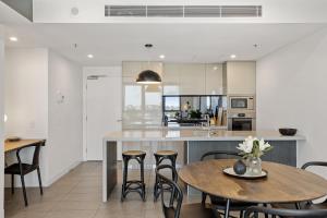 a kitchen and dining room with a table and chairs at Executive 2-Bed with Stadium View, Great Amenities in Brisbane