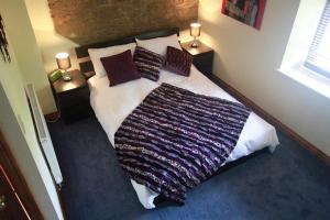 a bedroom with a large bed with a blanket on it at One Bedroom Character Cottage in Farthinghoe